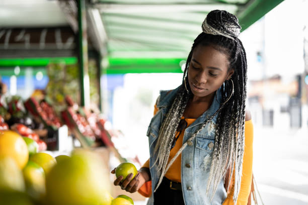 woman choosing fruits on street market - jamaican culture imagens e fotografias de stock