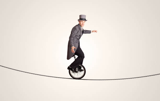 istock Extreme business man riding unicycle on a rope 964438334