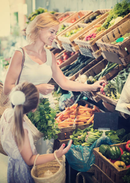 istock Glad mother with daughter shopping various veggies 964446838
