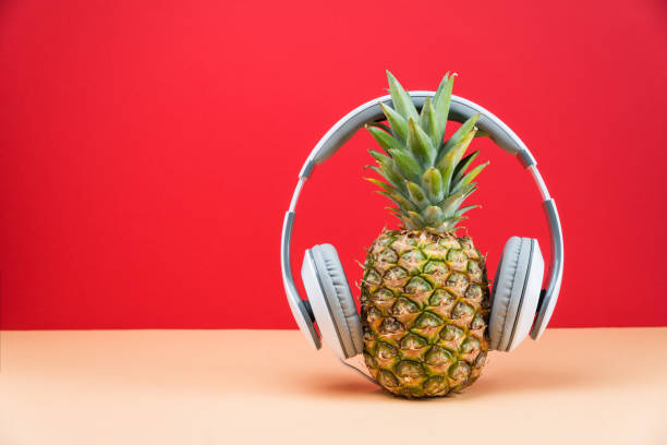 istock Music DJ concept, pineapple with headphones on red background 964461266