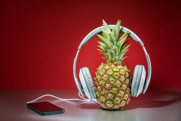 istock Music concept, pineapple with headphones, red background 964461310