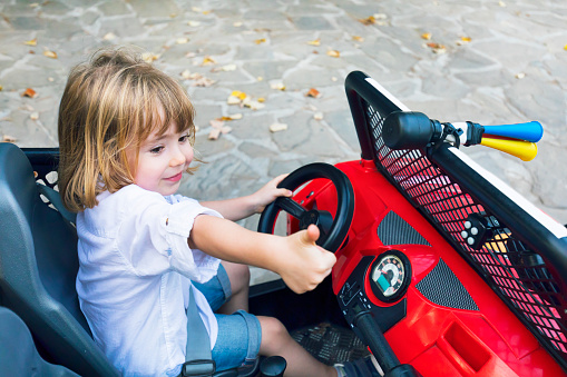 Cute child driving toy electric car