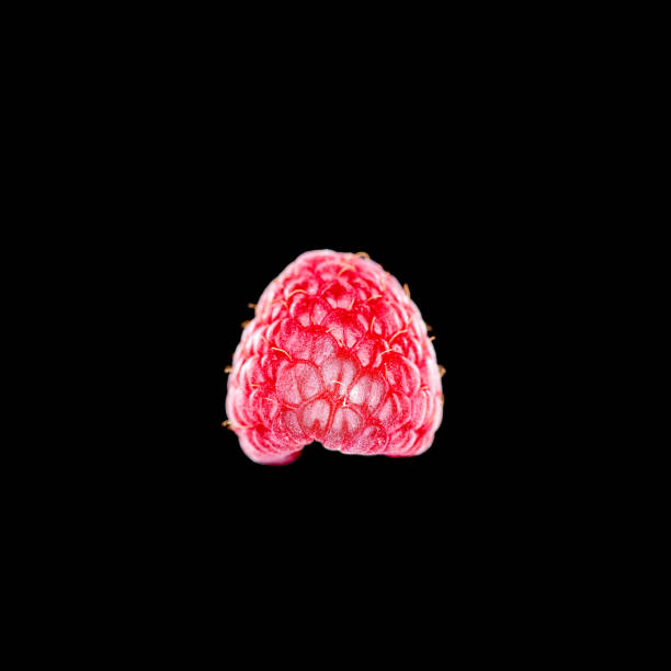 Top view of single ripe raspberry on black background, copy space around
