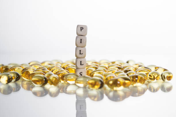 pílulas de palavra de suas letras de cubos e lecitina de gel pílulas sobre fundo claro. - gel effect capsule pill vitamin e - fotografias e filmes do acervo