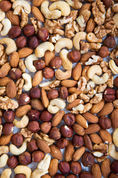 istock Mixed nuts (cashew, hazelnuts, walnuts, almonds) on white wooden background, top view. From above. 964500478