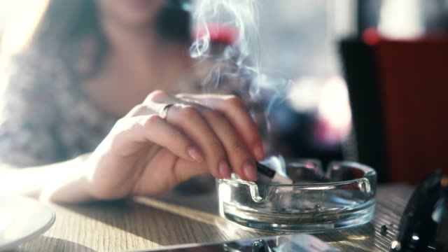 A young woman smokes in a cafe.
