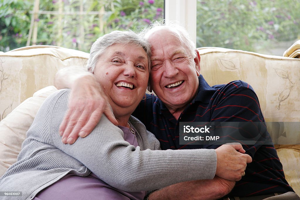 Heureux couple senior embrassant mutuellement à la maison - Photo de Adulte libre de droits