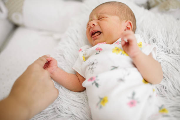istock Mother's hand stroking crying baby 964522898