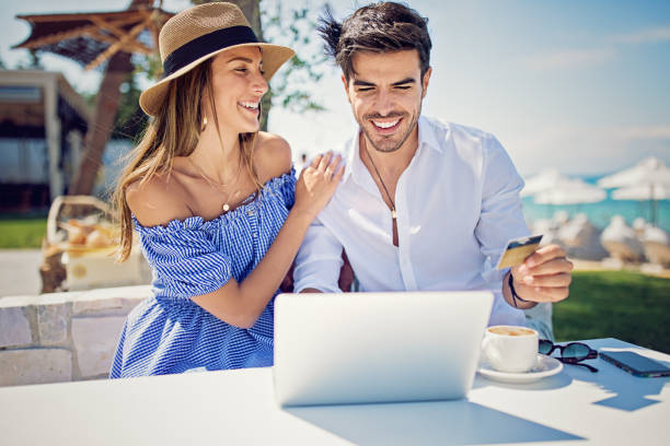 istock Couple is shopping online/making reservation on the beach 964536348