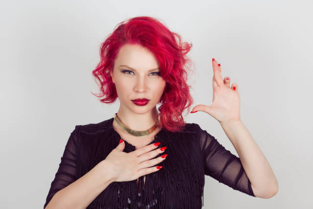 istock A liar. Woman sly witness making a false promise or testifies falsely hands gesture. Red head curly bob hairstyle girl isolated light gray white background. Mixed race hispanic caucasian fashion model 964551186
