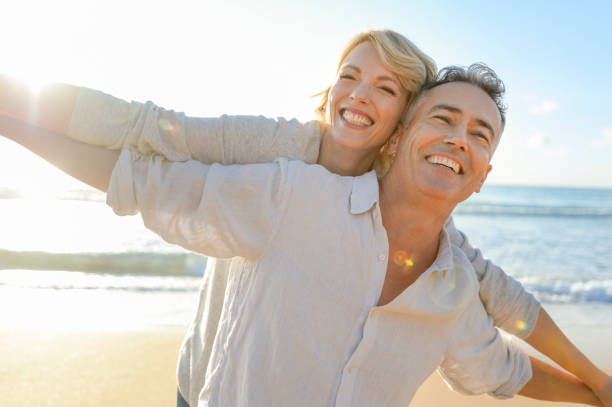 istock Mature couple playing on the beach at sunset or sunrise. 964551554