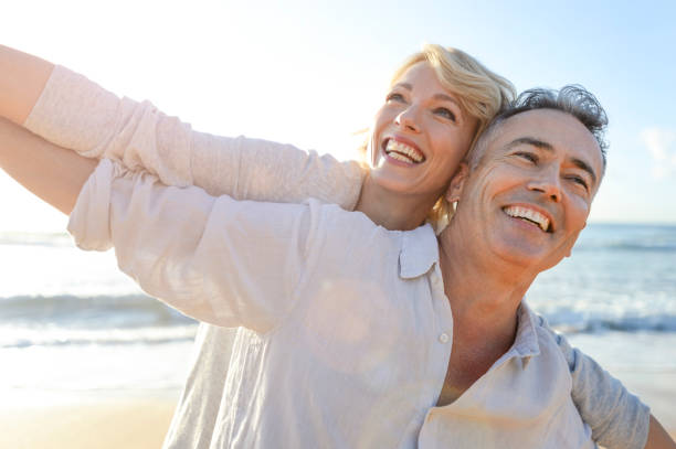 istock Mature couple playing on the beach at sunset or sunrise. 964551568