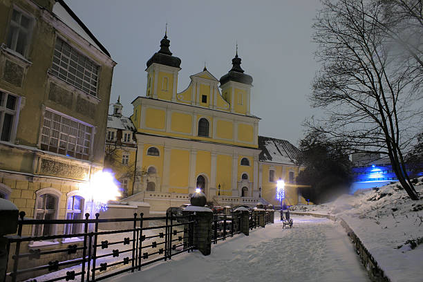 Winter city, snowfall, glowing lantern in the foreground. Monochrome, artificially created noise and grain effect.