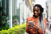 istock Afro Woman Using Mobile at Street 964584790