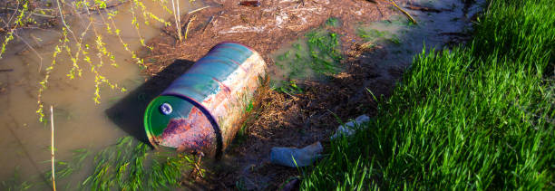 istock Barrel with toxic waste dumped into the river 964584800