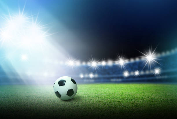 istock Soccer ball on green grass in stadium with spotlight 964594606