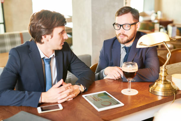 istock Pensive puzzled young business colleagues thinking about strategy while discussing company development analyzing graphs at pub 964608480