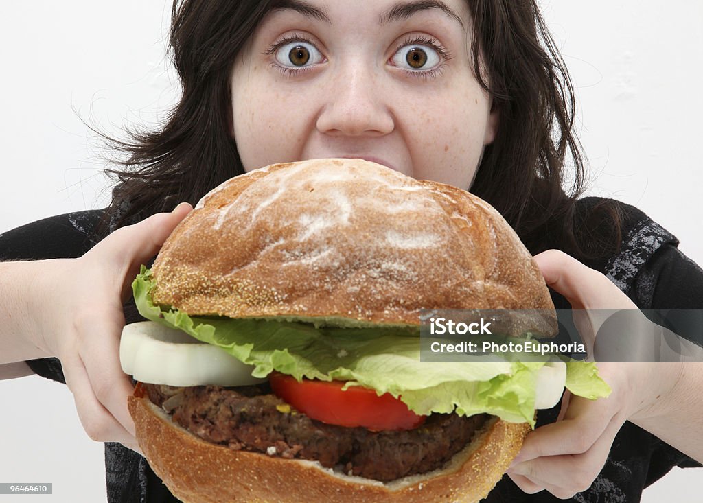 A woman getting ready to eat a giant hamburger Teenager girl eating a giant hamburger. Large Stock Photo