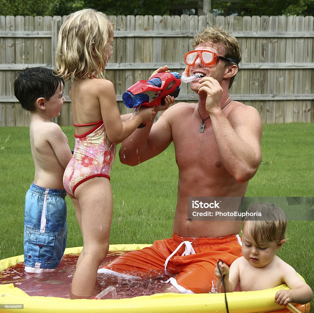 Boys and girl play with dad in the kids pool  Air Pump Stock Photo