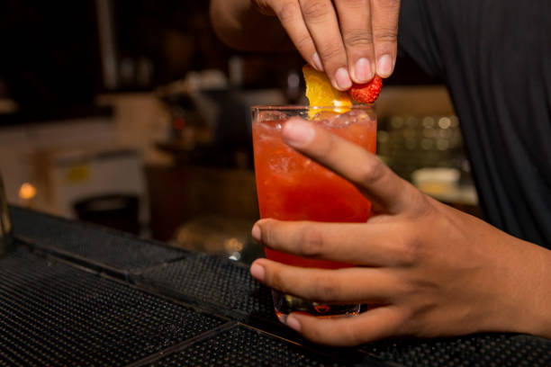 istock Male bartender placing fruits on glass 964671448