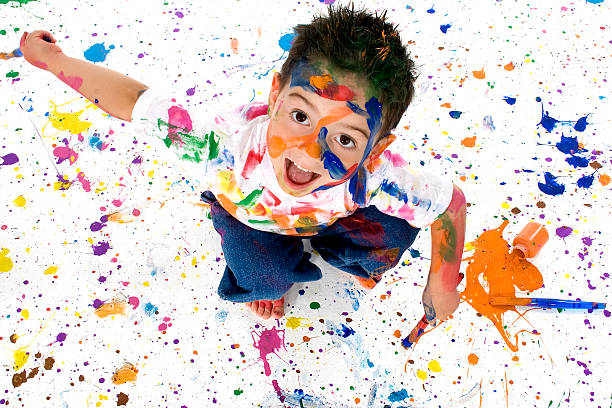istock Young child on white floor covered in multicolored paint 96470169