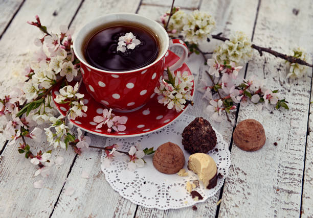 istock Red cup of tea with flowers and chocolates on planks 964719268