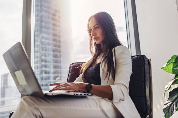 istock Young woman working on laptop sitting at home 964728720