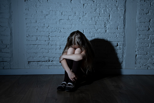 Triste niña desesperada sufre de bulling y acoso en la escuela photo