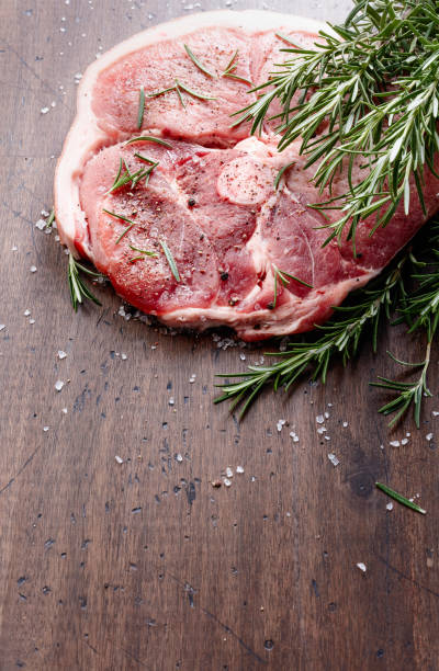 istock Raw pork with rosemary , salt and pepper. 964736330