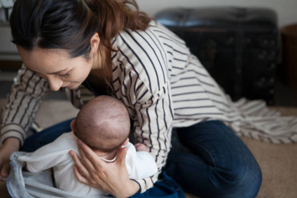istock Mother changing baby clothes. 964736800