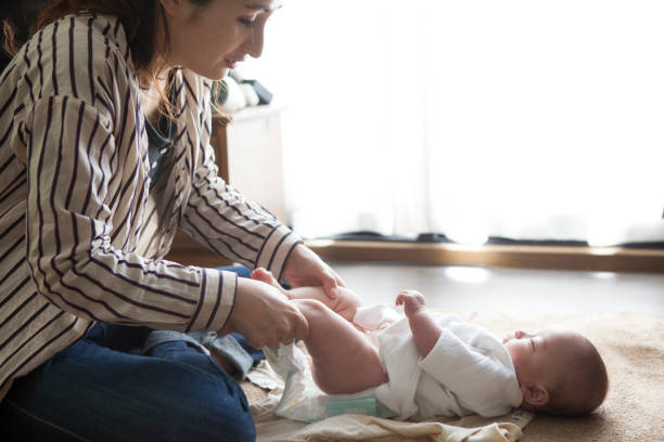 istock Mother changing baby clothes. 964736838