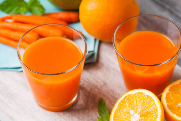 istock Glasses with carrot juice, apple, sliced orange and mint leaf 964742040