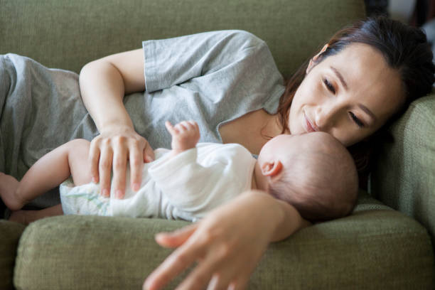 istock A baby sleeping with a mother who has an arm pillow. 964745300