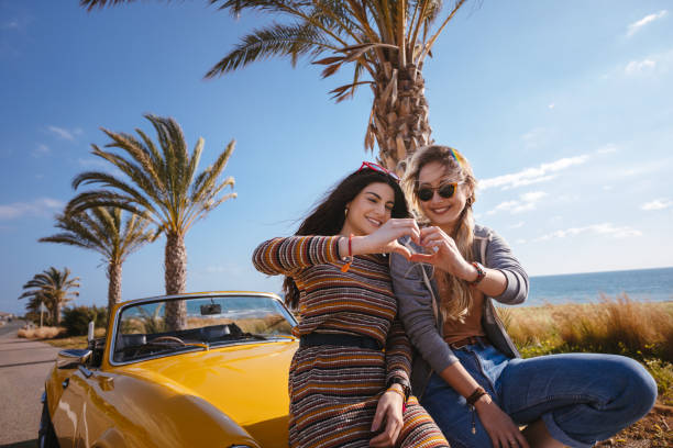 istock Women on road trip making heart shape with their hands 964748876
