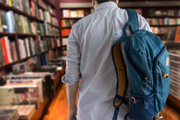 istock young man In the library books high school library 964754560