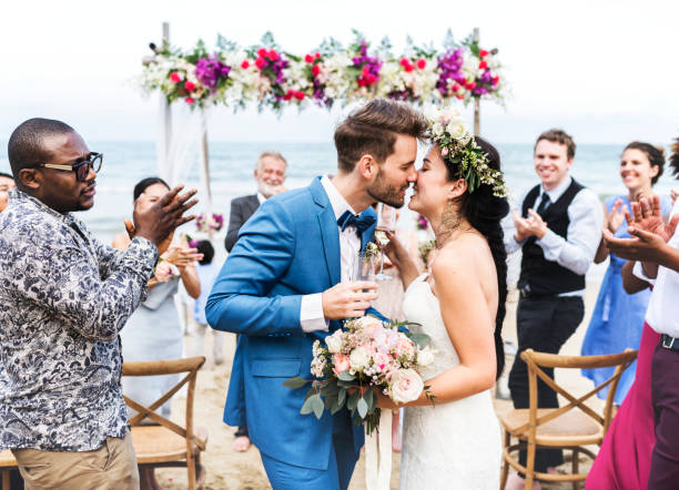 joven pareja besándose en la recepción de la boda - boda playa fotografías e imágenes de stock