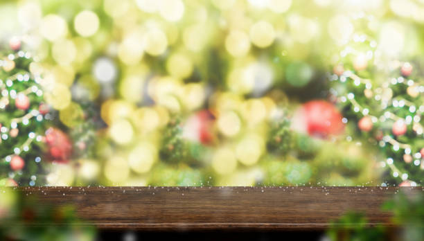 istock Empty dark brown wood table top with abstract blur christmas tree red decor ball and snow fall background with bokeh light,winter Holiday backdrop,Mock up for display of product.panoramic banner. 964755752