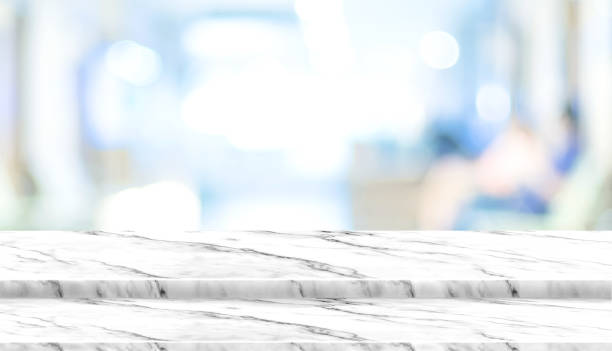 istock Empty step white marble table top with blur patient waiting for doctor at hospital with bokeh light at background,Mock up template for display of your design,Banner for advertise of product. 964755896