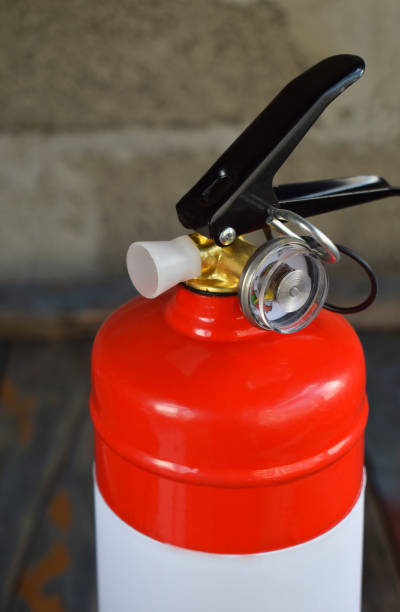 istock Compact red fire extinguisher for auto or home on grey background. For fire emergencies. 964758062