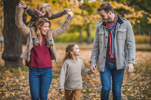 istock Young happy family communicating while taking a walk in autumn day. 964758138