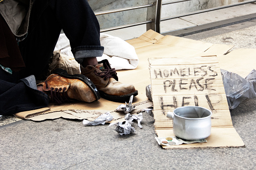 African senior man homeless and sleeping in the sidewalk streets of Johannesburg city centre, unhappy and hopeless.