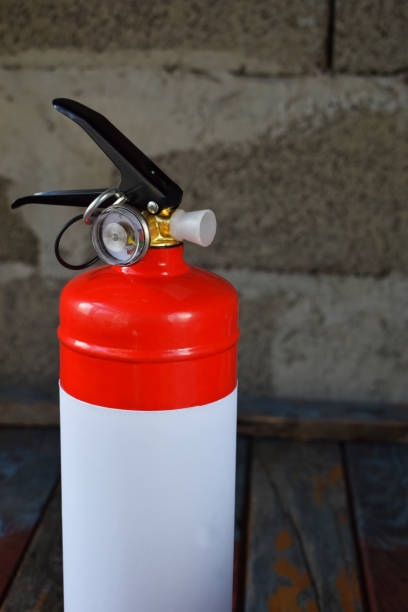 istock Compact red fire extinguisher for auto or home on grey background. For fire emergencies. 964758766