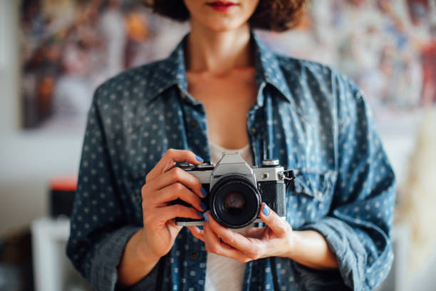 Hipster girl with retro camera taking photos