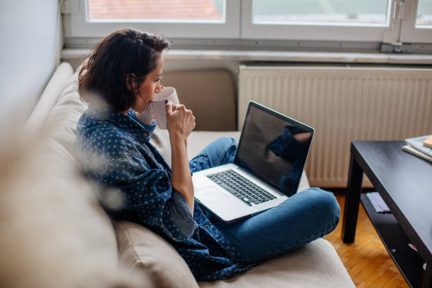 image recadrée de femme à l'aide d'ordinateur portable avec écran blanc - regarder par dessus son épaule photos et images de collection