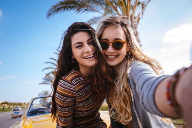 молодые хипстерские женщины в поездке весело принимают селфи - photographing smart phone friendship photo messaging стоковые фото и изображения