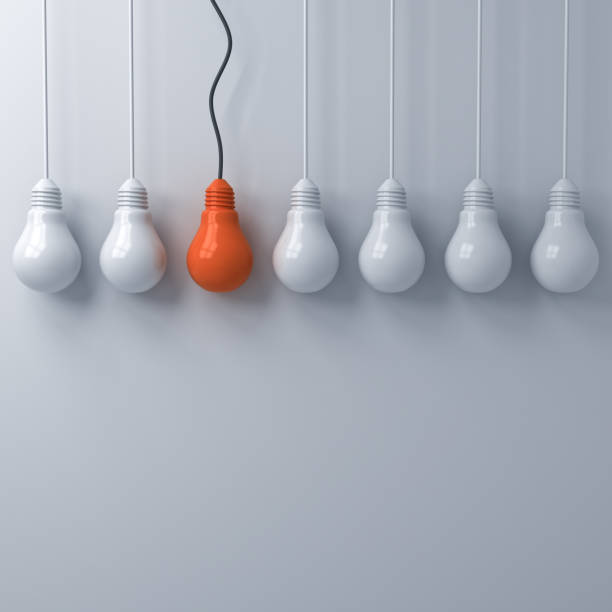 istock Think different concept , One hanging orange light bulb standing out from the unlit white lightbulbs on white wall background , leadership and individuality creative idea concepts 3D rendering 964774840