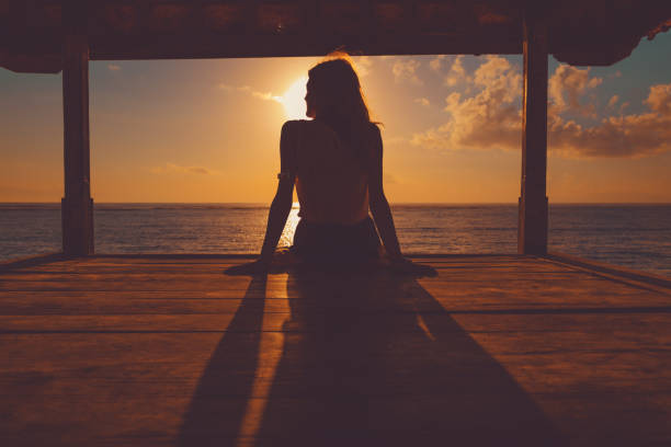 sylwetka dziewczyny cieszącej się na oceanie pagody. - zen like women temple meditating zdjęcia i obrazy z banku zdjęć