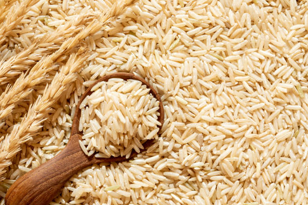 istock Brown rice in a wooden spoon on rice seed background 964782362