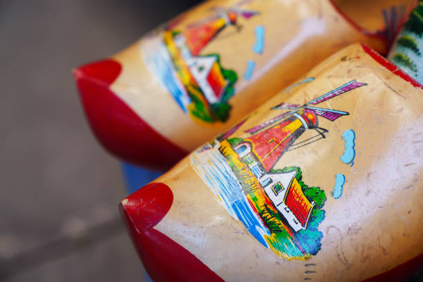 Woman wearing traditional dutch clogs, in the background is Amsterdam visible