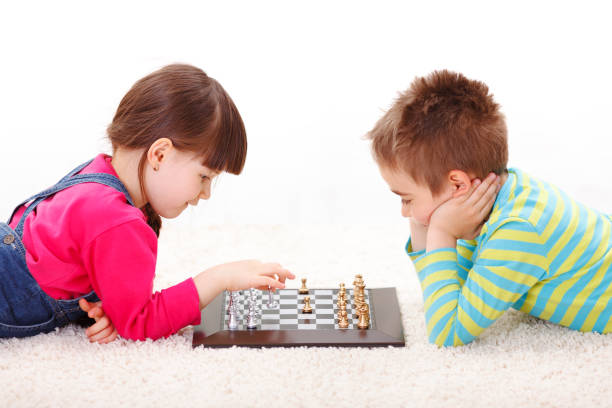 istock Little girl and boy playing chess 964785862